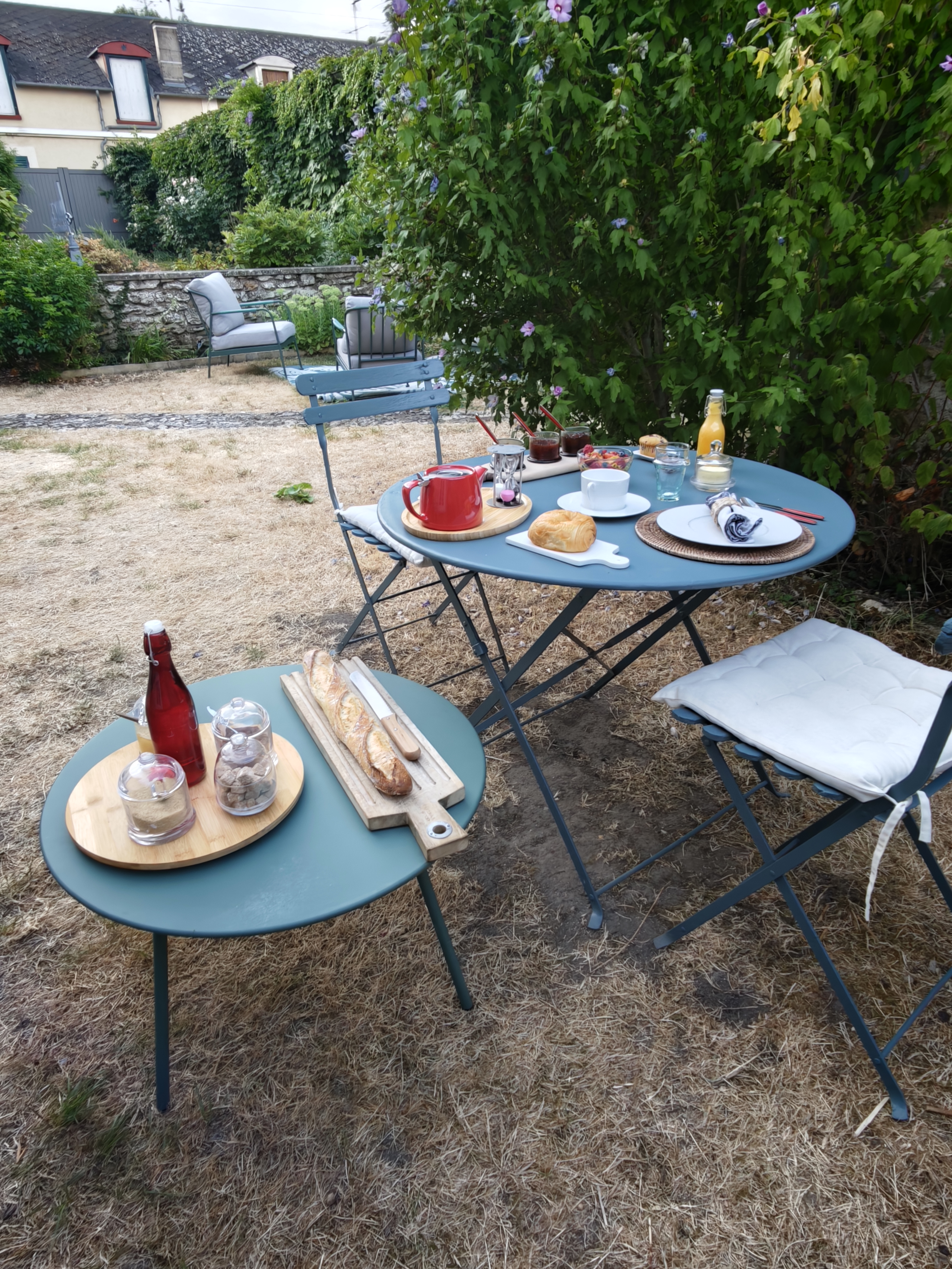 Petit-déjeuner maison servi au jardin, confitures et viennoiseries
